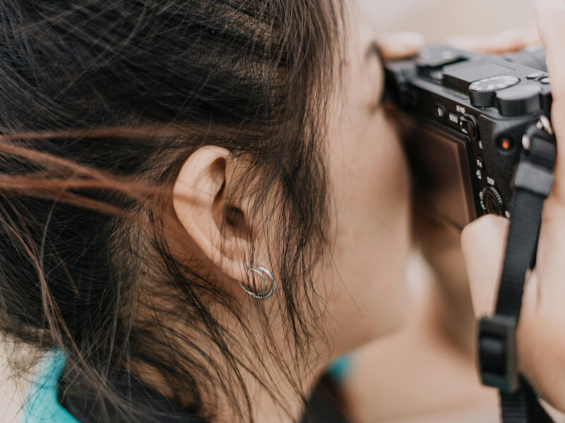 A woman holding a camera up to her eye